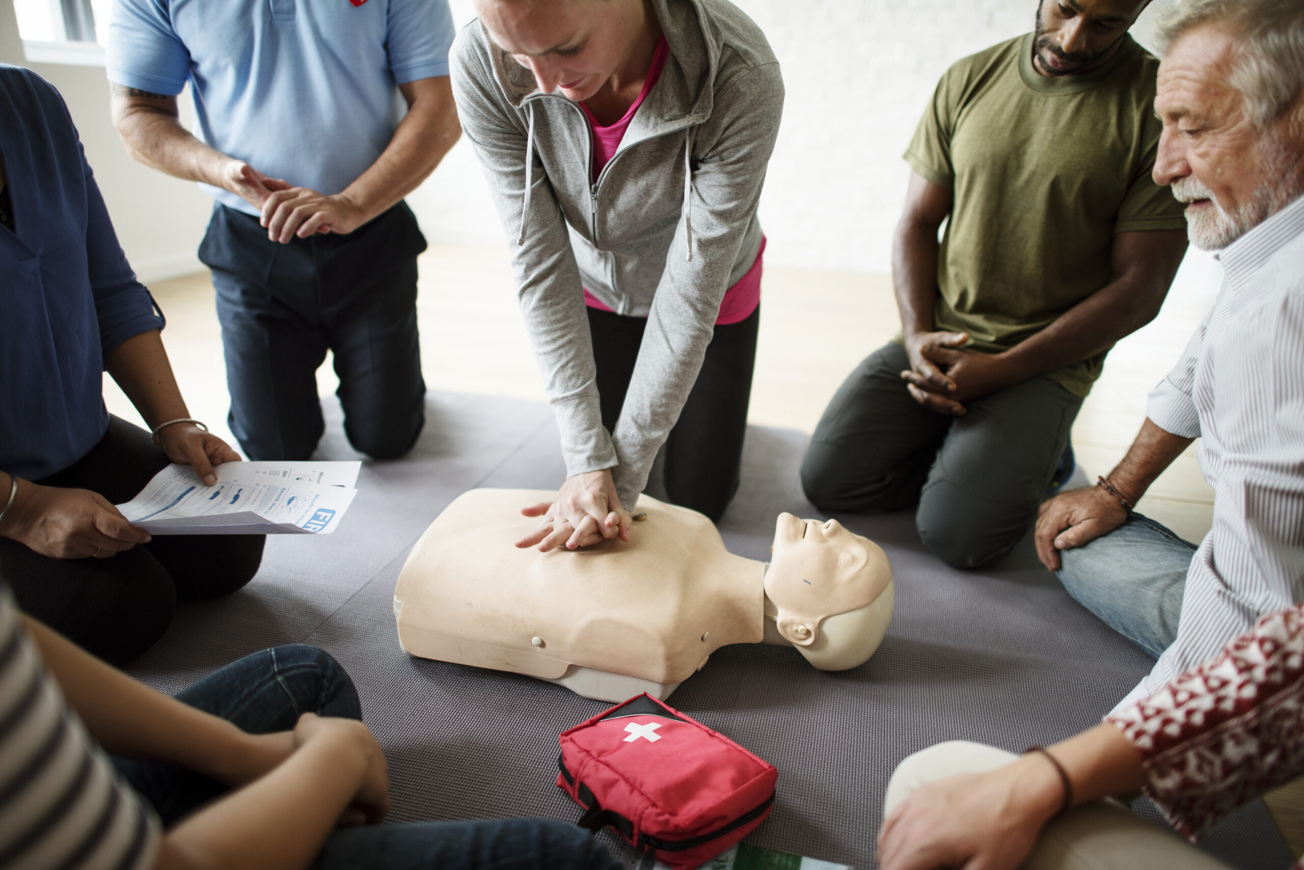 A group of people undertaking a basic life support training course
